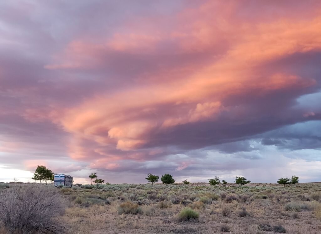 Captivating sunset over Arizona desert with vibrant clouds and open landscape.